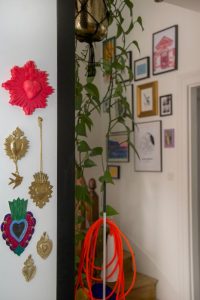 zoom sur un poteau habillé par des Ex-voto dont un moulage rose fluo de chez J'ai vu la vierge, câble orange fluo de la lampe Filo de chez Foscarini